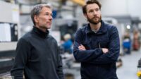 Produktionsleiter und Techniker besprechen eine technische Störung an einer Maschine.