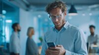 Employee receiving an emergency notification alert on a smartphone in a corporate office