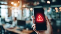 Smartphone displaying an urgent IT outage alert notification